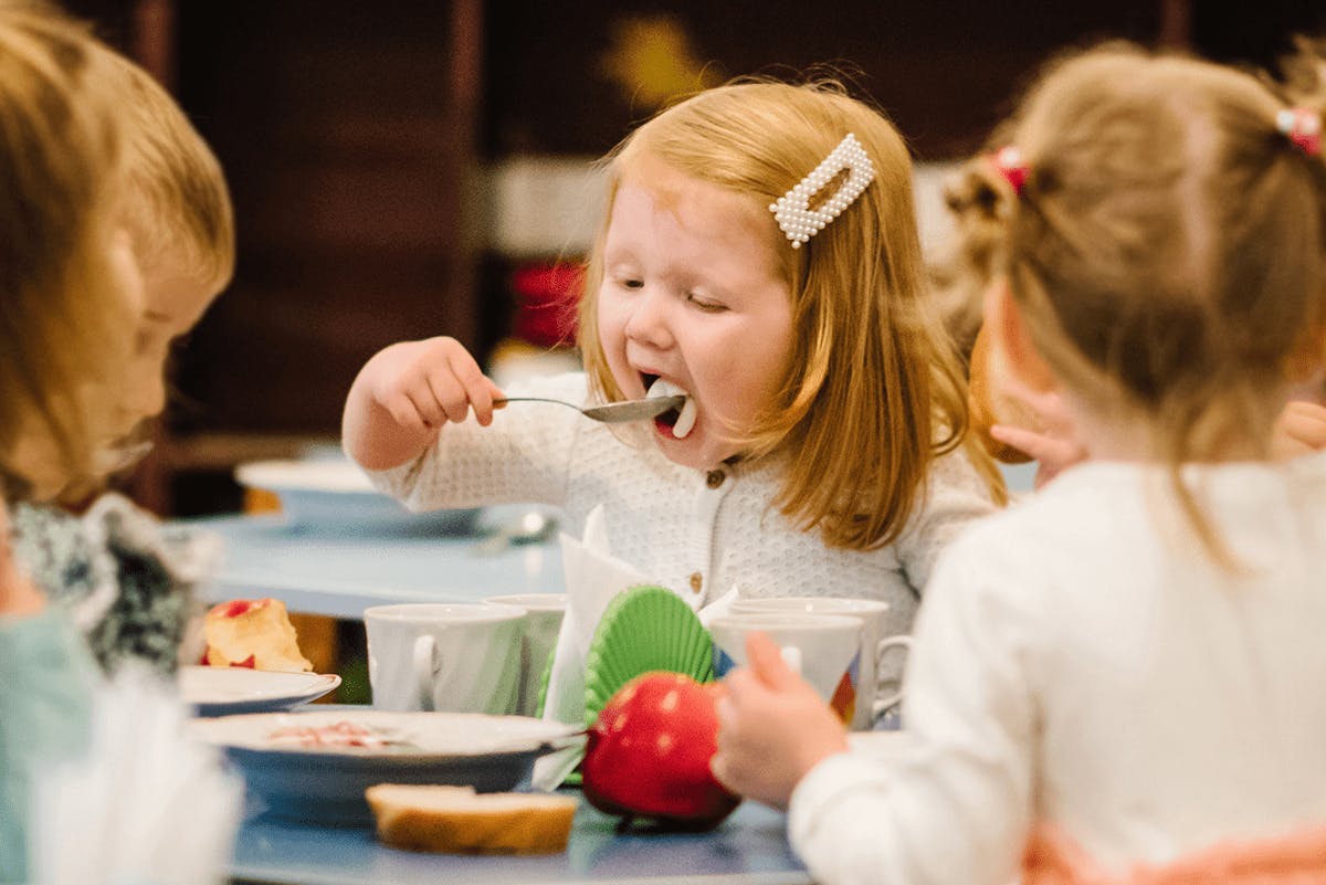 Barn i en skolmatsal som äter mat