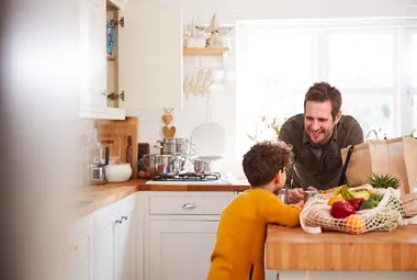 Pappa och son vid köksbänk