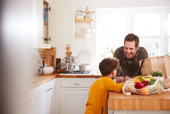 Pappa och son vid köksbänk