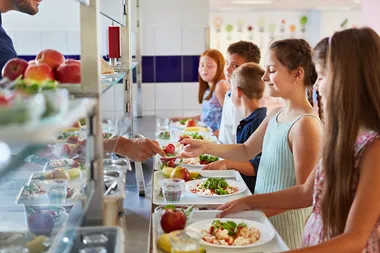 Skolbarn blir serverade grönsaker i skolan.