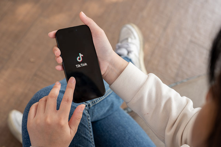 En hand håller en mobil som visar symbolen för TikTok.