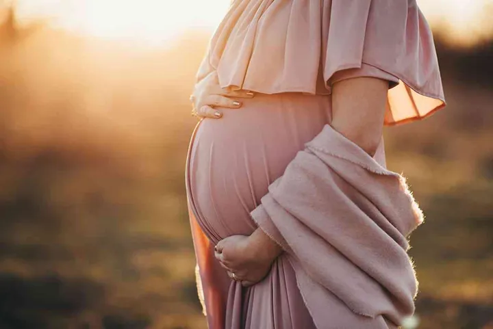pregnant woman in a dusty pink dress, sunset photoshoot